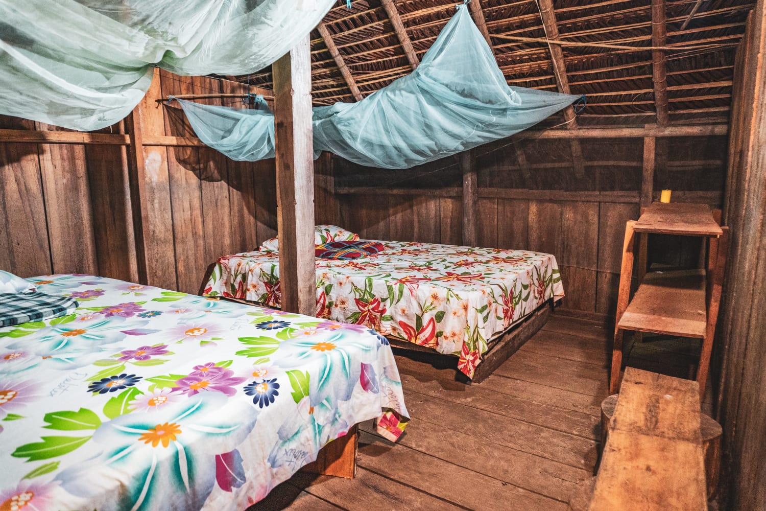 Interior de la cabaña comunitaria con camas y toldillos