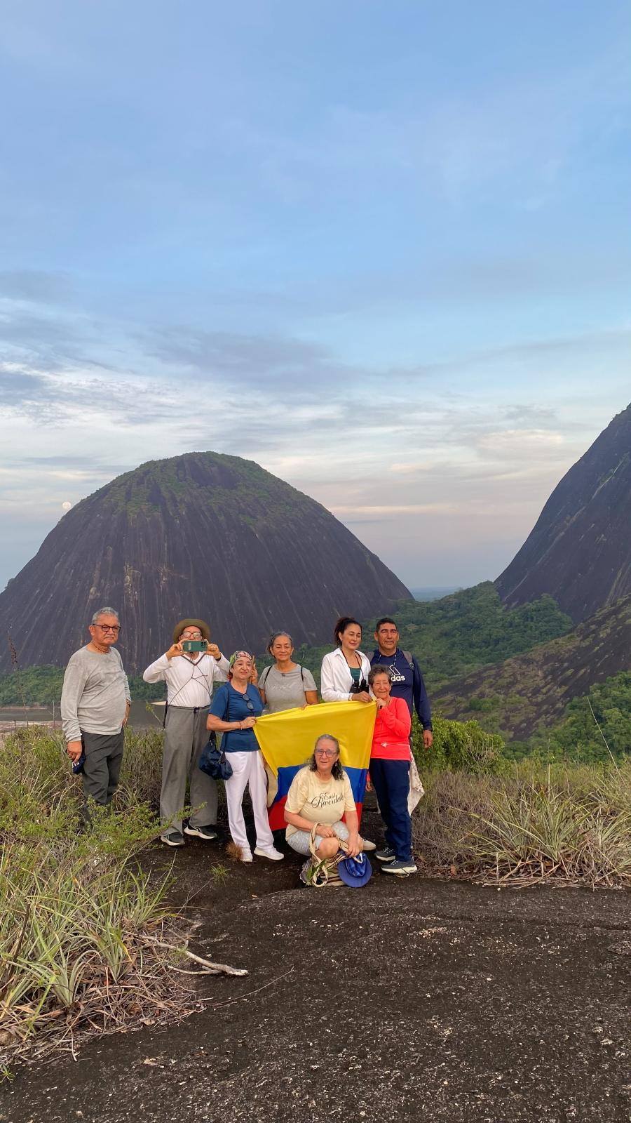 Grupo con la bandera de Colombia frente a los Cerros de Mavicure