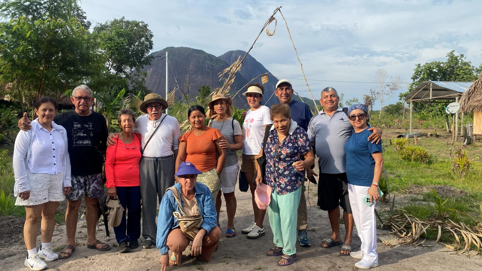 Grupo de viajeros con la comunidad de Venado y los cerros al fondo