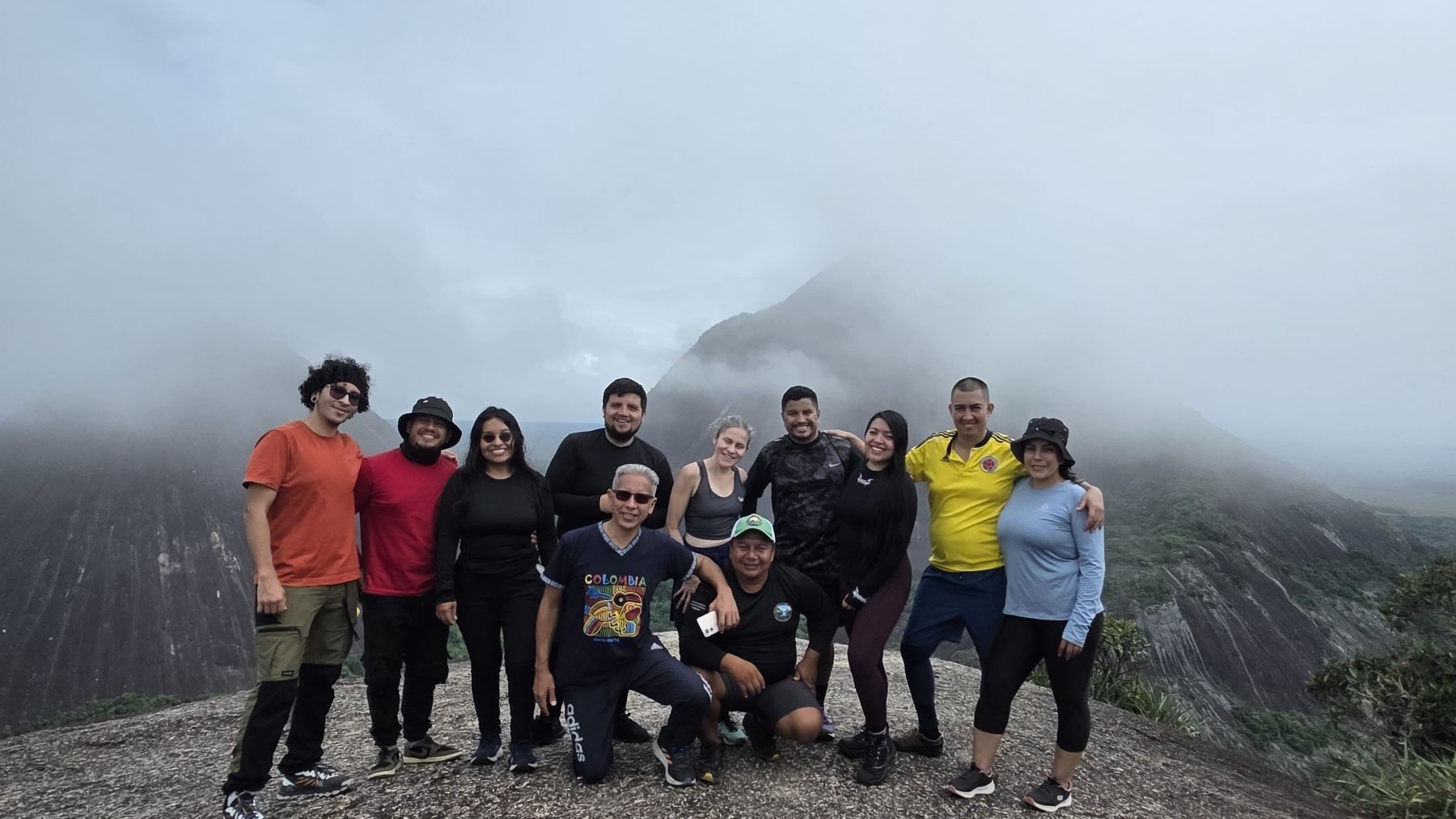 Grupo de viajeros en la cima entre la niebla